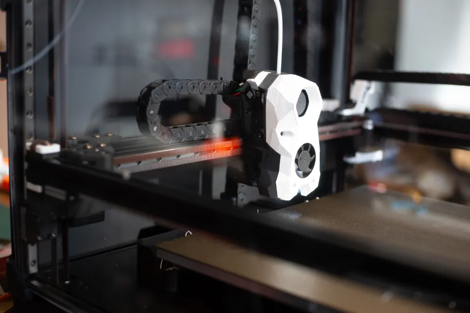 Cabeçote de uma impressora 3D fechada imprimindo uma peça